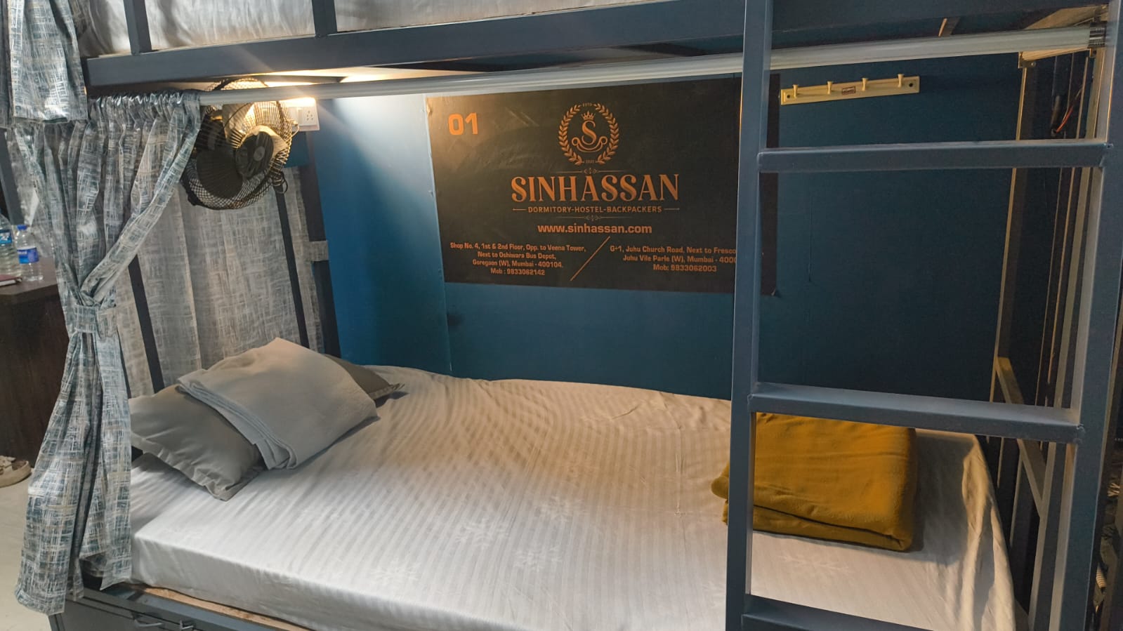 Clean made-up dormitory bed with privacy curtain
